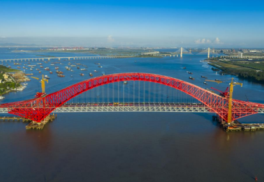 明珠湾大桥位于广州市南沙区龙穴南水道之上，是粤港澳大湾区的重要连接通道。大桥工程全长约10.42公里，主线全长约9.1公里，主桥采用中承式六跨连续钢桁拱桥，全长1016米，为同类型桥梁最大跨度。气势恢宏的明珠湾大桥绵延伸向远方，将南沙多条核心主干道紧紧连在一起，构筑了明珠湾区内部核心交通环，是广州面向粤港澳大湾区建设的交通枢纽工程和地标性建筑。图为南沙明珠湾大桥。