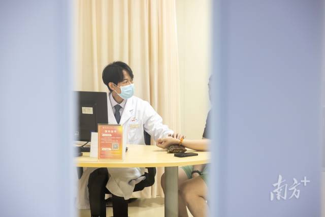 梁伟衡在给病人看诊。