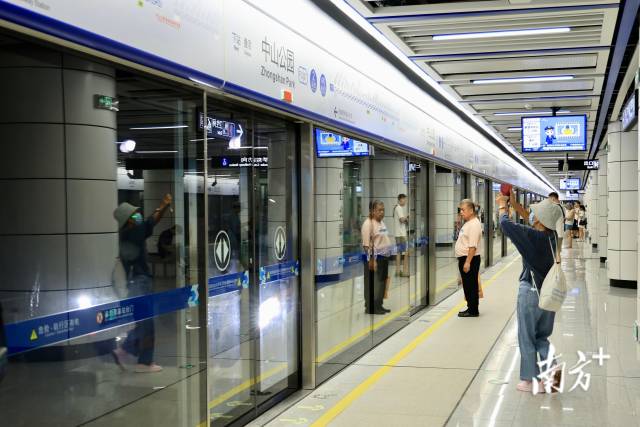 市民在中山公园站拍照留念、排队候车。刘佳伦 摄
