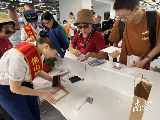 市民在桂城站便民服务台用明信片盖章打卡。龙西男 摄