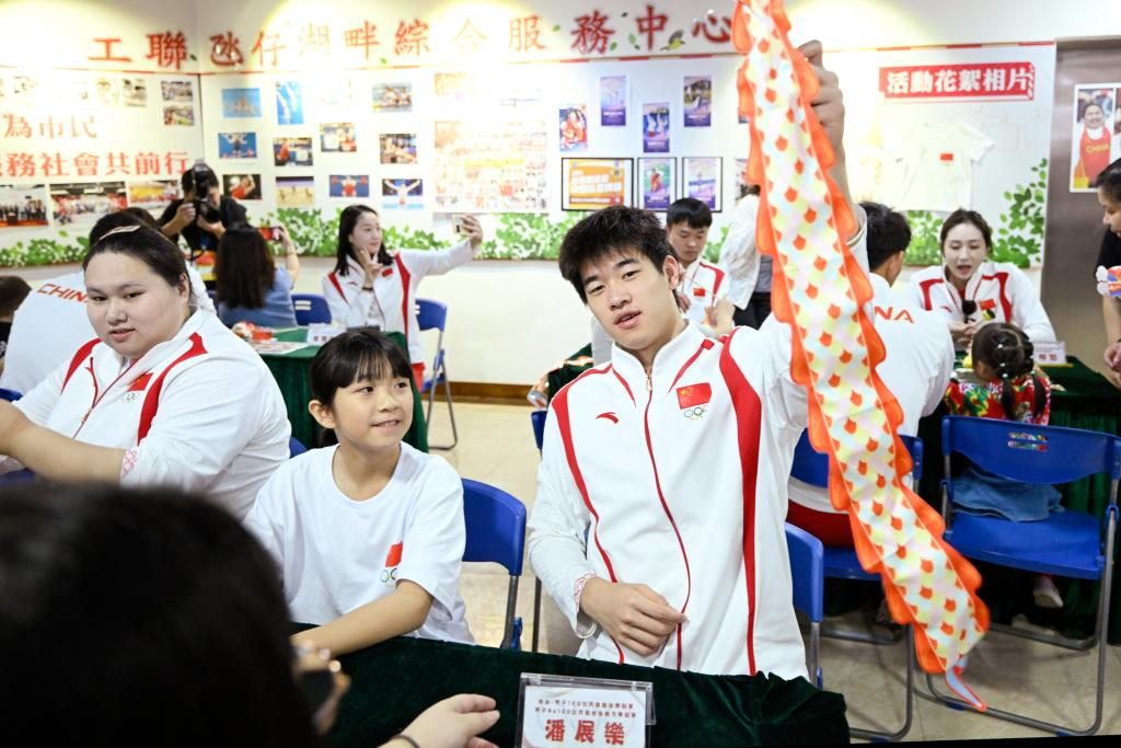 9月2日，在澳门工联氹仔湖畔综合服务中心，游泳运动员潘展乐（右）展示与小朋友一起制作的灯笼。当日，内地奥运健儿代表团走进澳门社区，分别到妇联乐满家庭服务中心、街总石排湾家庭及社区综合服务中心和工联氹仔湖畔综合服务中心与市民互动。新华社发