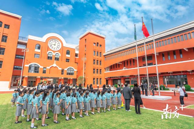 澳门新生身穿校服，背着书包来到濠江中学附属横琴学校报到。