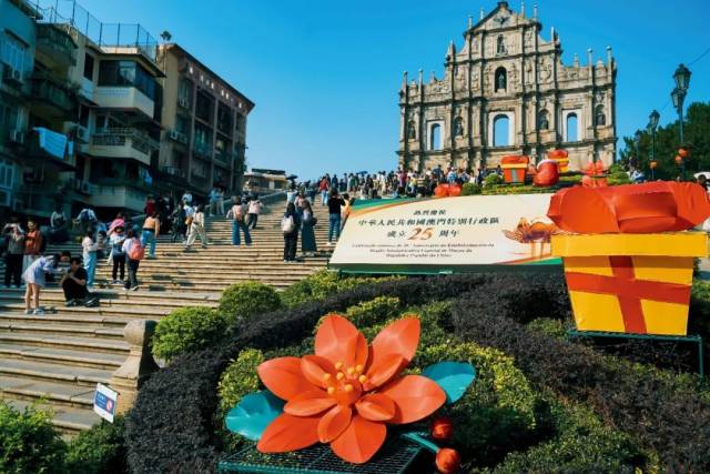 12月5日，澳门大三巴牌坊，“热烈庆祝中华人民共和国澳门特别行政区成立25周年”的标志吸引游客留影。图/视觉中国