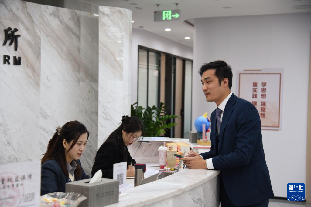 澳门律师阮嘉锐（右）在和同事交谈（12月19日摄）。新华社记者 洪泽华 摄