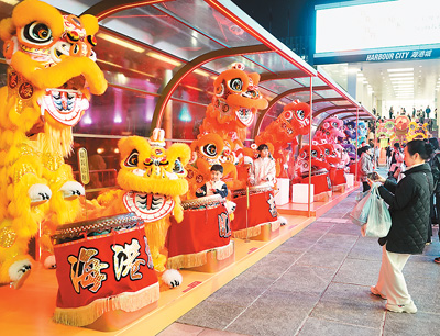 近日在香港维多利亚港畔，游客和醒狮合影。新华社记者 褚萌萌摄