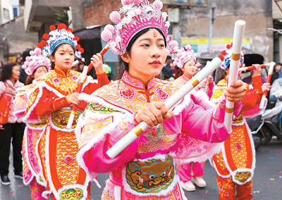  春节期间，英歌舞队员在广东省汕头市潮阳区海门镇街头巡游表演。王文摄（人民视觉）
