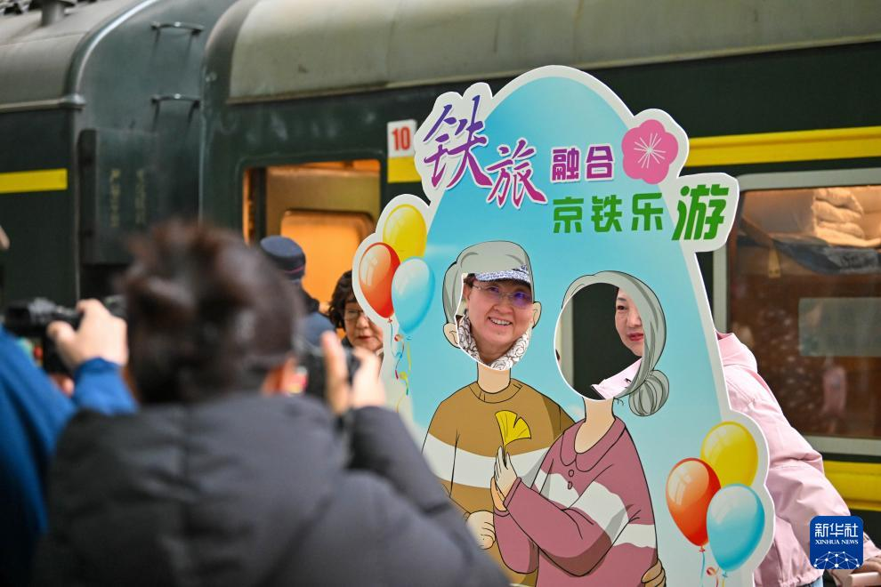 3月15日，在天津站站台，银发族游客在“京铁乐游”号银发旅游列车发车前拍照留念。新华社记者 孙凡越 摄