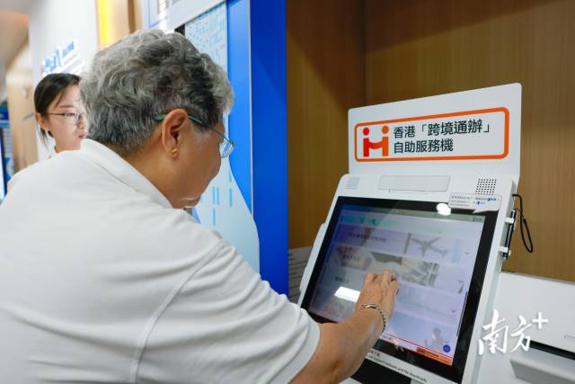 香港市民尝试使用香港“跨境通办”自助服务机。 