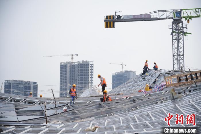 建设者们忙于幕墙工程、金属屋面、机电安装、精装修施工。记者 韦杰夫 摄