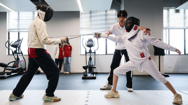 图为广东现代五项运动协会教练员肖勇炫（右二）纠正广州市中黄港澳子弟学校港籍生尹泽语的击剑技术动作